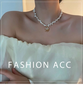 Detailed view of baroque pearl necklace with gold auspicious lock pendant on model