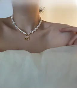Baroque pearl necklace detail with a golden cloud pendant worn on model neck