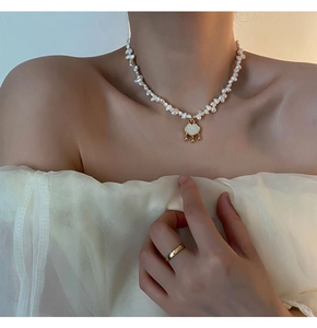 Detailed view of Baroque pearl necklace with golden cloud pendant on a female model