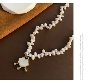 Close-up of Baroque pearl necklace with gold Ruyi lock pendant and white shell inlay