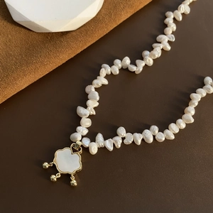 Elegant baroque pearl necklace featuring a white shell lock pendant with golden tassels