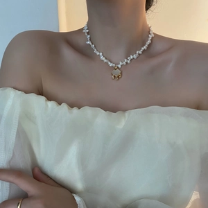 Baroque pearl necklace featuring a shell ruyi lock pendant on an elegant female model