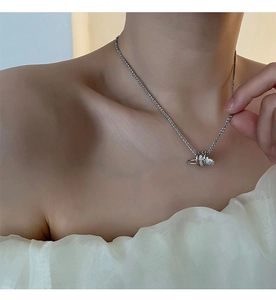 Dettaglio della collana in titanio argento con pendente a spilla da balia in zirconi