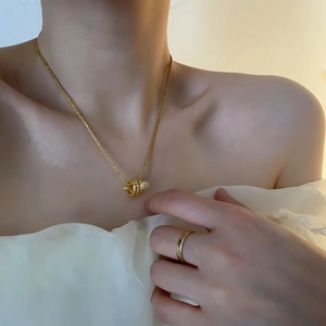 Elegante girocollo in oro con pendente a cilindro scintillante su una modella
