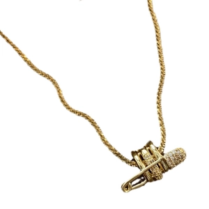 Collana con ciondolo a spilla da balia dorata con zirconi su catena sottile in titanio
