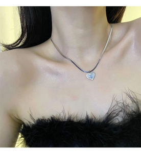 Gros plan du pendentif cœur bleu iridescent avec une élégante chaîne serpent argentée