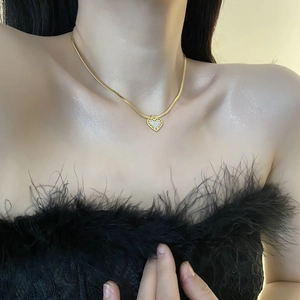 Collier élégant chaîne serpent dorée avec pendentif cœur nacre sur le cou