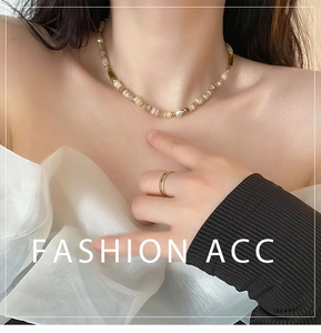 Gros plan d'un collier vintage en pierres naturelles et bague dorée sur un mannequin