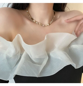 Gros plan d'un collier vintage avec perles en pierre naturelle brune et perles blanches