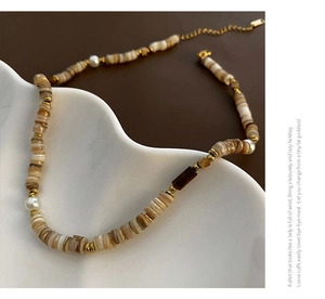 Détail macro d'un collier de perles fait main avec coquillages naturels et perles