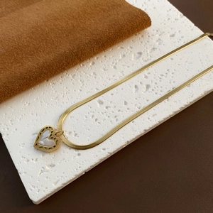 Collar dorado con colgante de corazón de nácar blanco y cadena de serpiente elegante