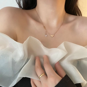 Rose gold heart pendant necklace with zircon stone on model with white organza top