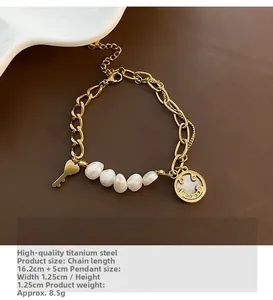 Close-up of baroque pearl smile bracelet with gold titanium chain and key pendant detail