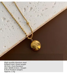 Detailed view of lucky engraved pendant on gold bead and snake chain necklace