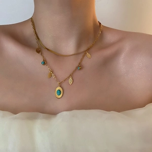 Collana a doppio strato vintage dorata con ciondoli a foglia e turchese su modella