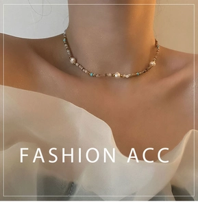 Detail of beaded pearl choker with sky blue accents worn on model's neck for elegant look