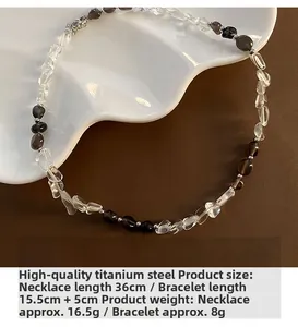 Set collana e bracciale in acciaio al titanio con perline di cristallo su piatto bianco