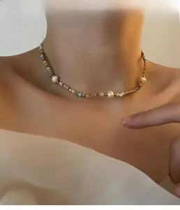 Detail view of a luxury natural pearl necklace with colorful beads on a model's neck