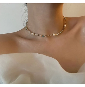 Detailed shot of handmade choker with freshwater pearls, blue turquoise, and gold beads
