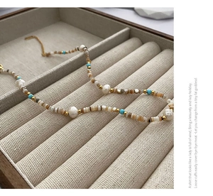 Detailed close-up of bohemian style necklace with baroque pearls and colorful stone beads