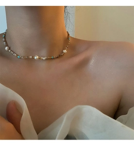 Detail of luxury beaded choker with natural pearls and turquoise on a woman's neck