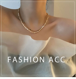 Close-up of a double-layered gold bead and white pearl necklace on a model's neck