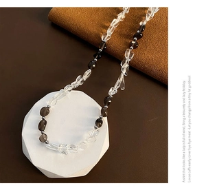 Vista dettagliata della collana asimmetrica in cristallo con accenti d'argento sul supporto