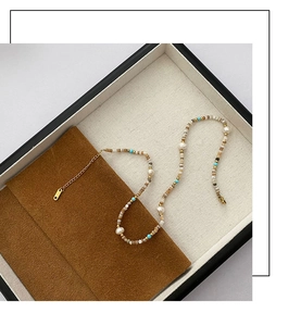 Detail of luxury beaded necklace with natural pearls, blue turquoise and gold chain