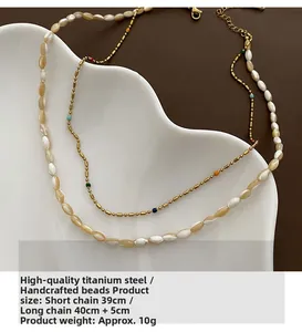 Detail of double-layer beaded necklace featuring white shell beads and gold titanium chain