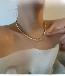 Close-up of double-layered beaded necklace with gold accents and shell beads on model