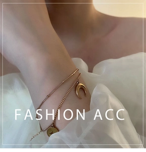 Détail du bracelet doré multicouche étoile et lune sur poignet avec fond en tulle