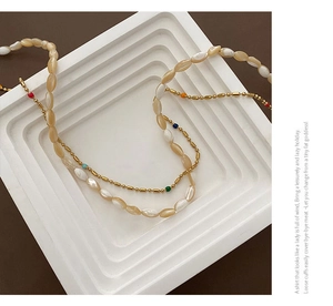 Detail of double-layer shell beaded necklace with colorful accents on tiered display
