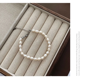 Détail macro d'un bracelet en perles baroques naturelles avec fermoir argenté dans son écrin