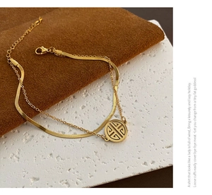 Close-up of double-layered gold-plated snake chain with a round hollow pendant detail