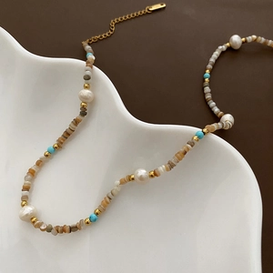 Luxurious bohemian necklace with natural baroque pearls, golden beads and colorful shell chips