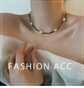 Detail of vintage turquoise and natural pearl beaded choker on model's neckline
