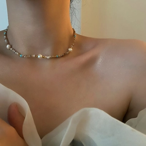 Elegant beaded necklace with natural pearls and turquoise stones on female model neck