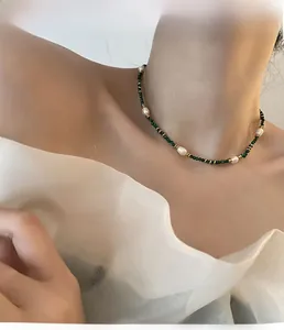 Detail of handmade pearl and turquoise necklace on model showcasing the choker style