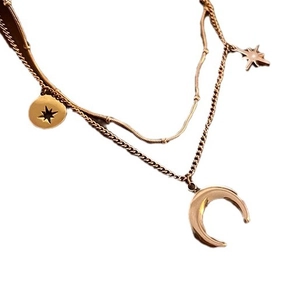 Collier double rang en or rose avec pendentifs lune et étoile sur fond blanc épuré