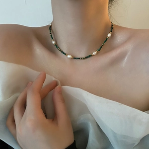 Exquisite pearl and turquoise beaded choker necklace with gold accents worn by a model