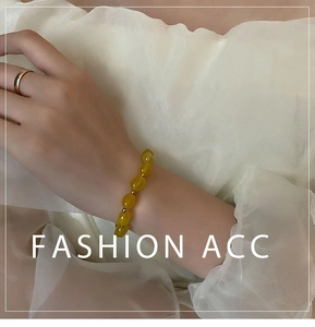 Détail de perles en pierre naturelle jaune avec séparateurs dorés sur bracelet ajustable