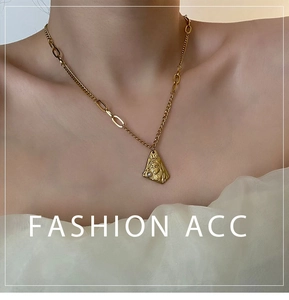 Detail of vintage gold necklace featuring an embossed face pendant and a white pearl accent