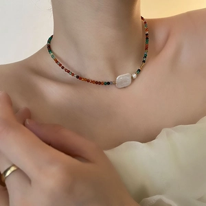 Elegant Baroque pearl necklace with multi-colored beads on model's neckline