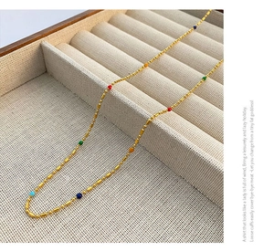 Close-up of golden beaded collar necklace with vibrant multi-colored small round beads