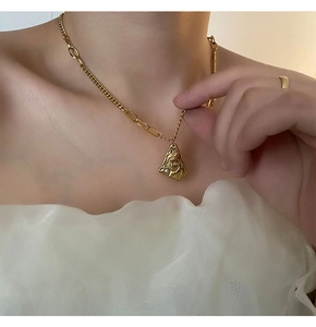 Close-up of gold vintage portrait medallion necklace with pearl on a female neck