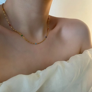 Elegant gold titanium necklace with colorful beads on a model, stylish clavicle chain