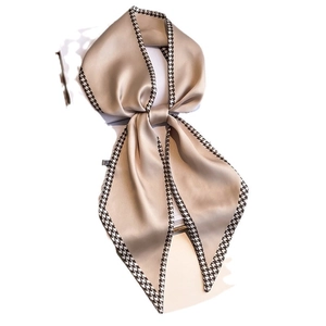 Champagne houndstooth silk scarf tied in a bow on a minimalist white background