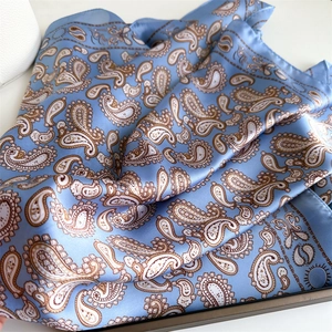 Detailed view of sky blue paisley pattern silk scarf with elegant rolled edges