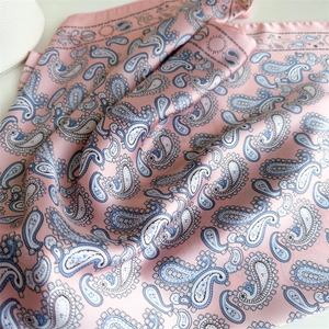Elegant pink paisley silk scarf with blue patterns, soft draped texture for sun protection
