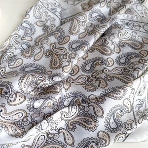 Detailed view of the soft paisley pattern and silky fabric texture on this scarf